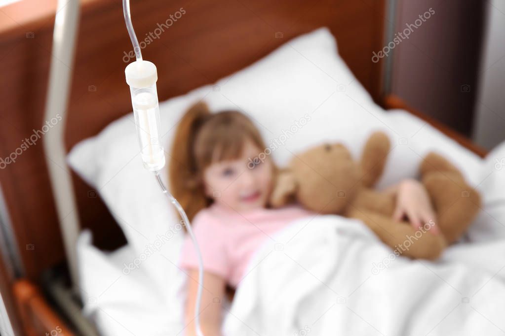 Little child with intravenous drip sleeping in hospital bed