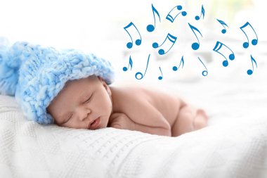 Şirin Bebek yatak ve uçan müzik notlar üzerinde uyku örgü şapkalı. Ninni şarkı