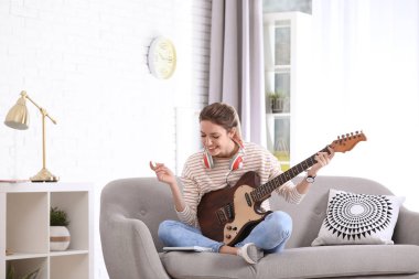 Elektro gitar oturma odasında şarkı beste olan kadın
