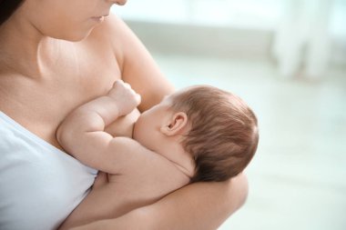 Genç kadın anne sütü bebeği arka plan bulanık, closeup üzerinde