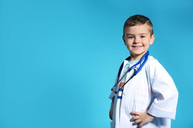 Doktor stetoskop renk arka plan üzerinde paltoyla şirin çocuk. Metin için yer