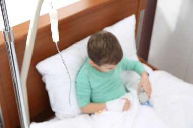 Hastane yatağında, damla odası odaklanmak intravenöz infüzyon ile küçük çocuk