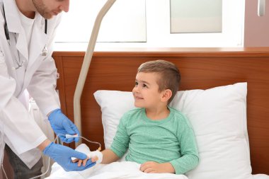 Doktor intravenöz damla küçük çocuğun hastanede kalması için ayarlama