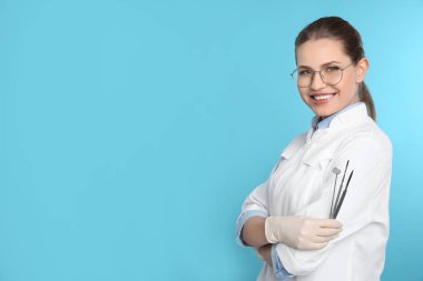 Kadın diş hekimi profesyonel araçlar renk arka plan üzerinde tutarak. Metin için yer
