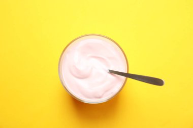 Kaymaklı Yoğurt ve renk arka plan, üstten görünüm kaşık ile cam kase
