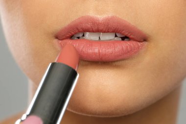 Genç kadın ruj rengi arka planda, closeup uygulama