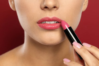 Genç kadın ruj rengi arka planda, closeup uygulama