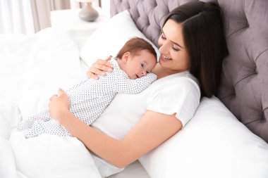 Şirin bebeği yatakta mutlu kadınla