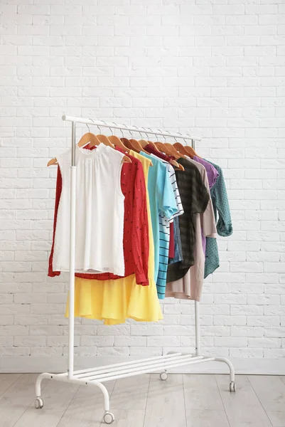 衣柜架与时尚的衣服靠近砖墙室内 文本的空间 — 图库照片