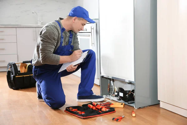 Técnico Masculino Con Portapapeles Examinando Refrigerador Cocina — Foto de Stock