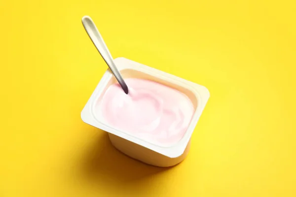 Copa Plástico Con Yogur Cremoso Cuchara Sobre Fondo Color — Foto de Stock