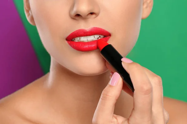 Mujer Joven Aplicando Lápiz Labial Sobre Fondo Color Primer Plano — Foto de Stock