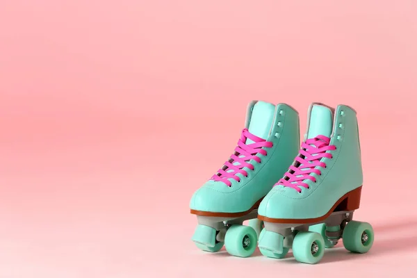 Pair of vintage roller skates on color background. Space for text