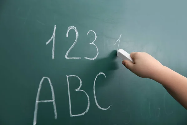 小さな子供のクローズ アップ 黒板に文字と数字を書く — ストック写真