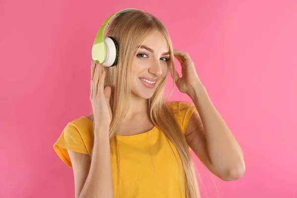 Schöne Junge Frau Hört Musik Mit Kopfhörern Auf Farbigem Hintergrund — Stockfoto