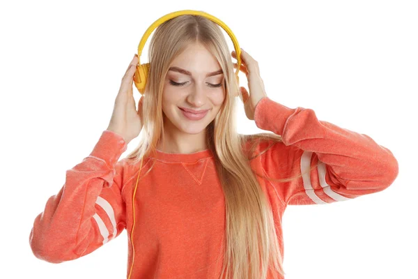 背景色の上にヘッドフォンで音楽を聴く若い美人 — ストック写真