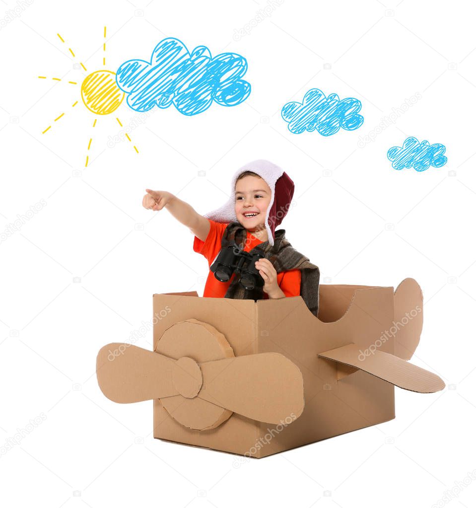 Cute little boy playing with cardboard plane and drawing of clouds on white background