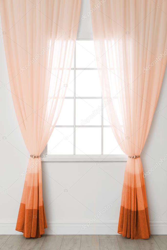Modern window with stylish orange curtains indoors