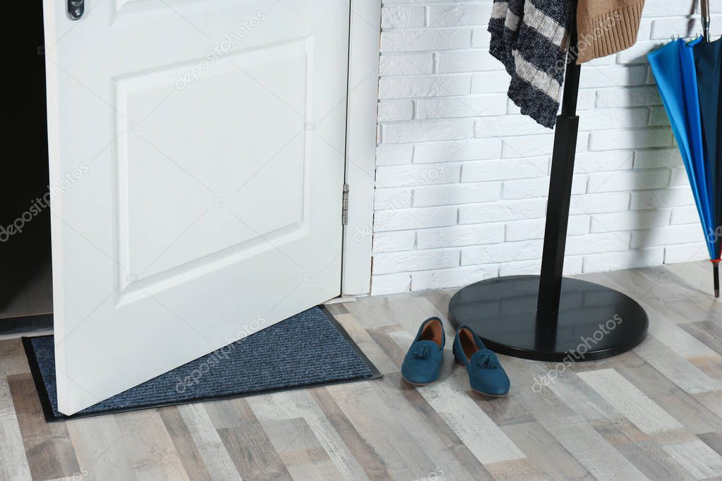 Hallway interior with mat and clothes stand near door