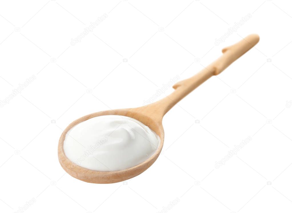 Spoon with creamy yogurt on white background