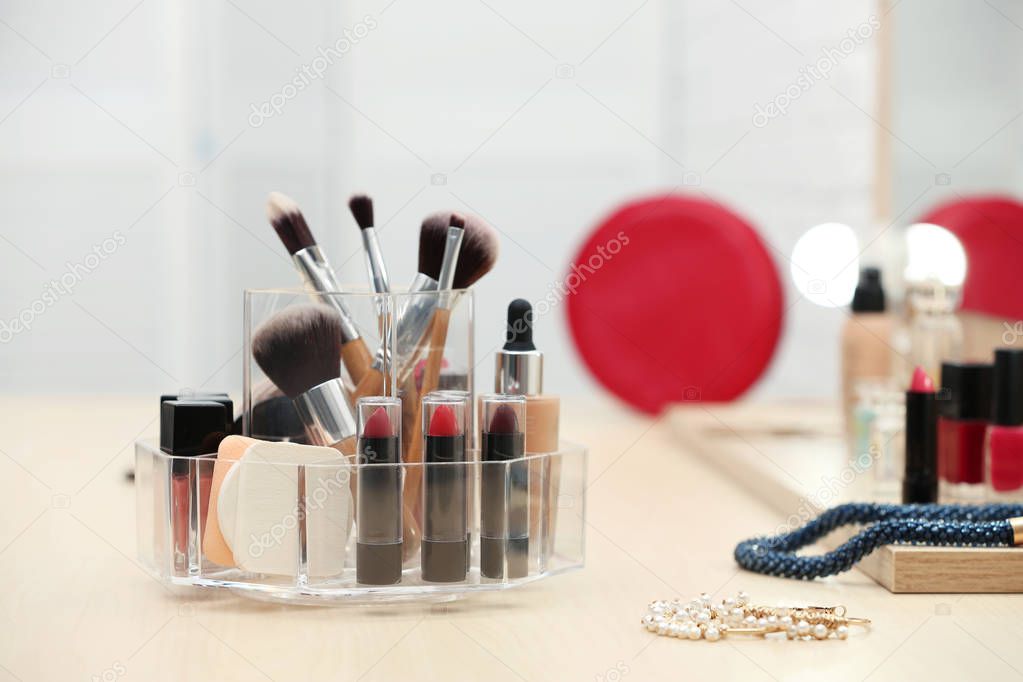 Organizer with cosmetic products and makeup accessories on dressing table