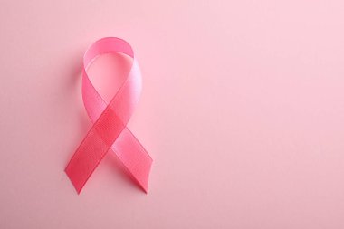 Renk arkaplan üzerine pembe kurdele, metin için boşluk ile üst görünüm. Göğüs kanseri farkındalığı konsepti