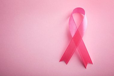 Renk arkaplan üzerine pembe kurdele, metin için boşluk ile üst görünüm. Göğüs kanseri farkındalığı konsepti