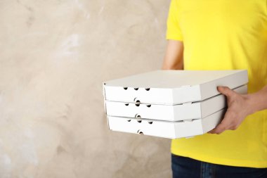 Pizza kutuları renk arka plan, metin için yer üzerinde olan genç adam. Gıda dağıtım hizmeti