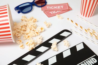 Clapper, patlamış mısır ve beyaz arka plan üzerinde bilet. Sinema snack