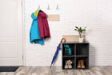 Ayakkabı raf ve asılı giysileri tuğla duvar ile şık koridor iç