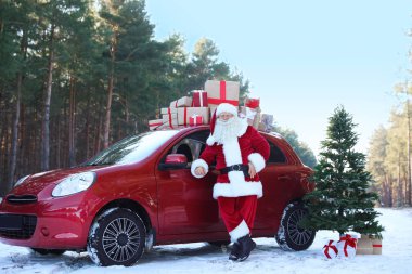 Otantik Noel Baba hediye kutuları ve Noel ağacı, açık havada kırmızı araba yakınındaki
