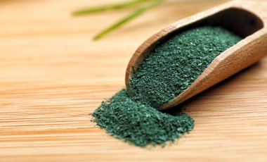 Spirulina tozu ahşap masa, closeup üzerinde kepçe. Metin için yer