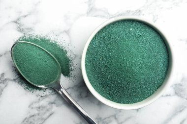 Kase ve kaşık spirulina yosun tozu mermer zemin, üstten görünüm