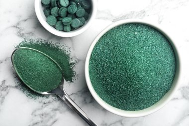Spirulina yosun toz ve mermer zemin, üstten görünüm üzerine hap kompozisyonu