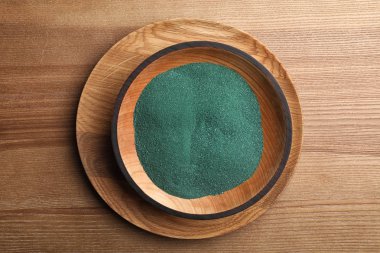 Ahşap arka plan, üstten görünüm üzerinde spirulina tozu ile kase