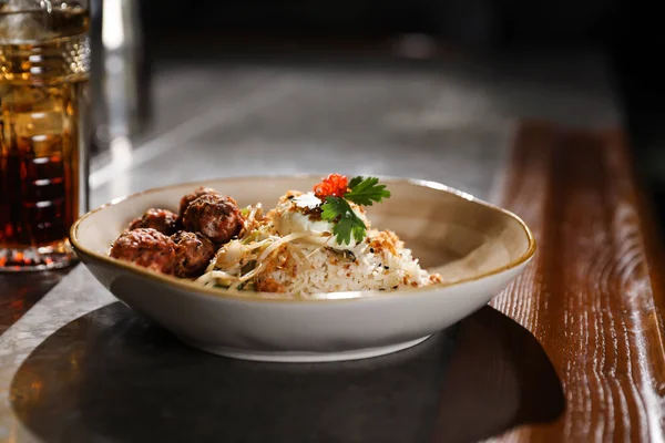 Plate with rice and meat balls served on table