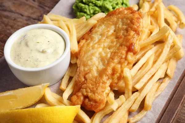 British traditional fish and potato chips on wooden board, closeup