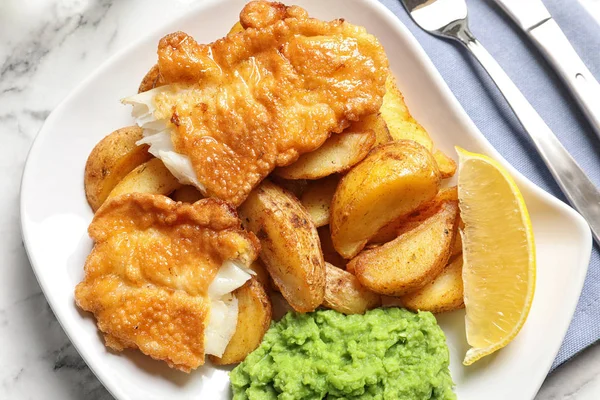 Plate with British traditional fish and potato chips, top view