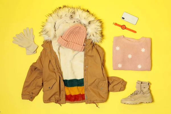 Flat lay composition with warm female clothes for winter vacation on color background