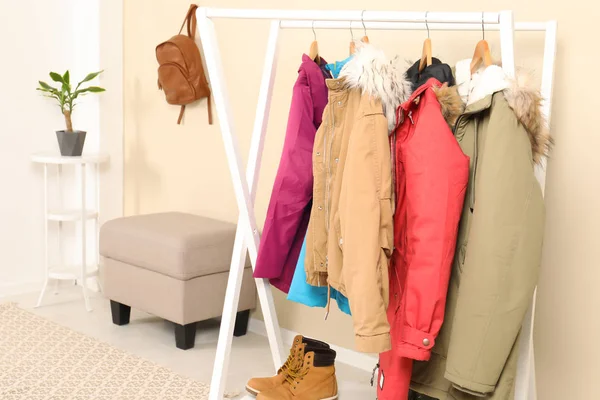 Stylish hallway interior with clothes on hanger stand