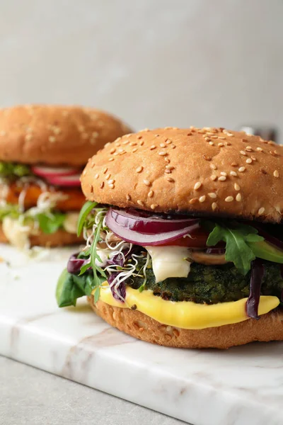 Tasty vegetarian burgers on marble board