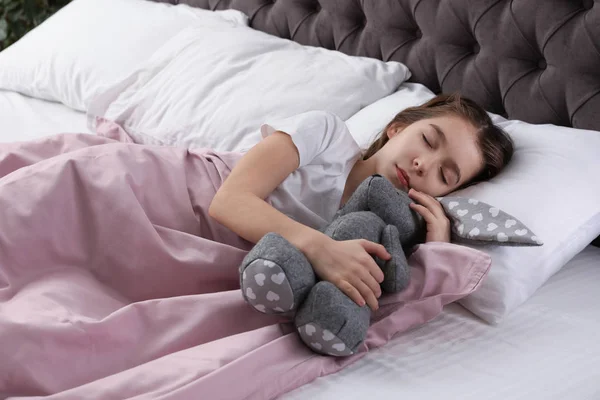 Schönes Kleines Mädchen Mit Spielzeugkaninchen Das Bett Schläft — Stockfoto