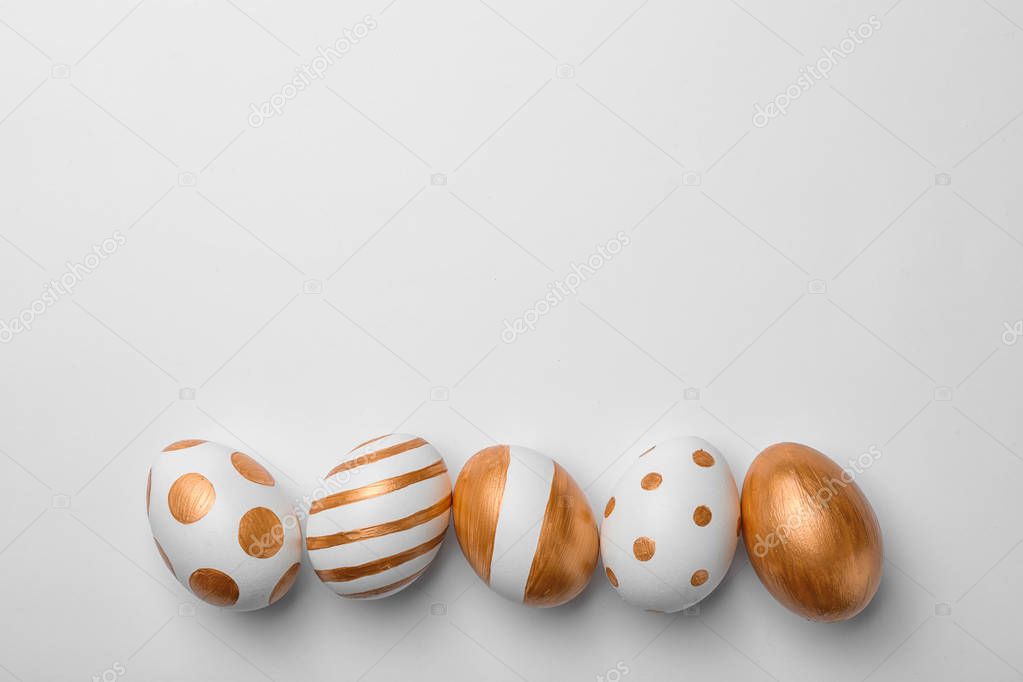 Set of traditional Easter eggs decorated with golden paint on white background, top view. Space for text