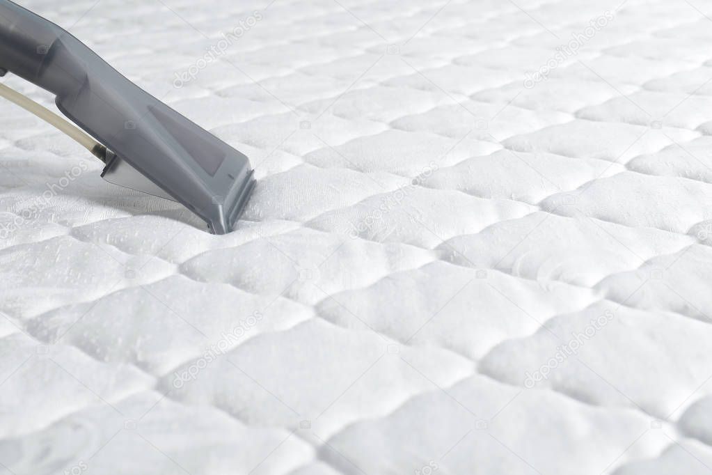 Using modern vacuum cleaner for mattress disinfection, closeup. Space for text