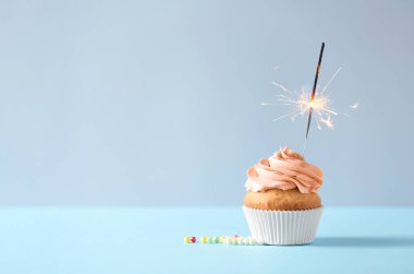 Açık renkli karşı masada maytap yanma ile lezzetli turuncu kek. Metin için yer 