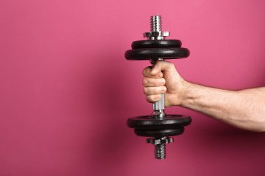 Erkek atlet renk arka plan üzerinde metal dumbbell tutarak. Metin için yer