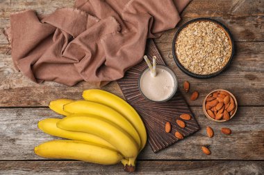 Sağlıklı protein içeceği ve malzemeler ahşap arka plan üzerinde düz yatıyordu kompozisyonu