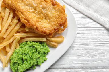 İngiliz geleneksel balık ve patates cipsi ahşap arka plan, closeup ile plaka