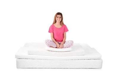 Yatak kazık beyaz arka plan üzerinde oturan kadın