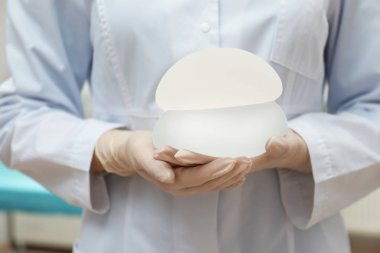 Meme büyütme Kliniği, closeup için doktor holding silikon implantlar. Kozmetik cerrahi
